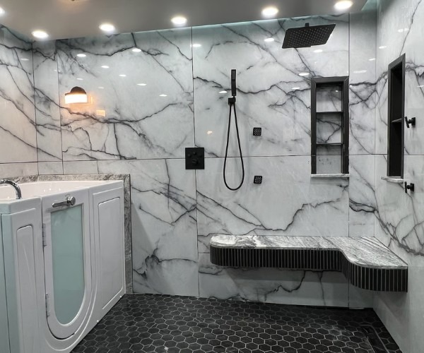 Marble tile walk in shower with rainfall head black fixtures bench and a frosted door walk in tub on left